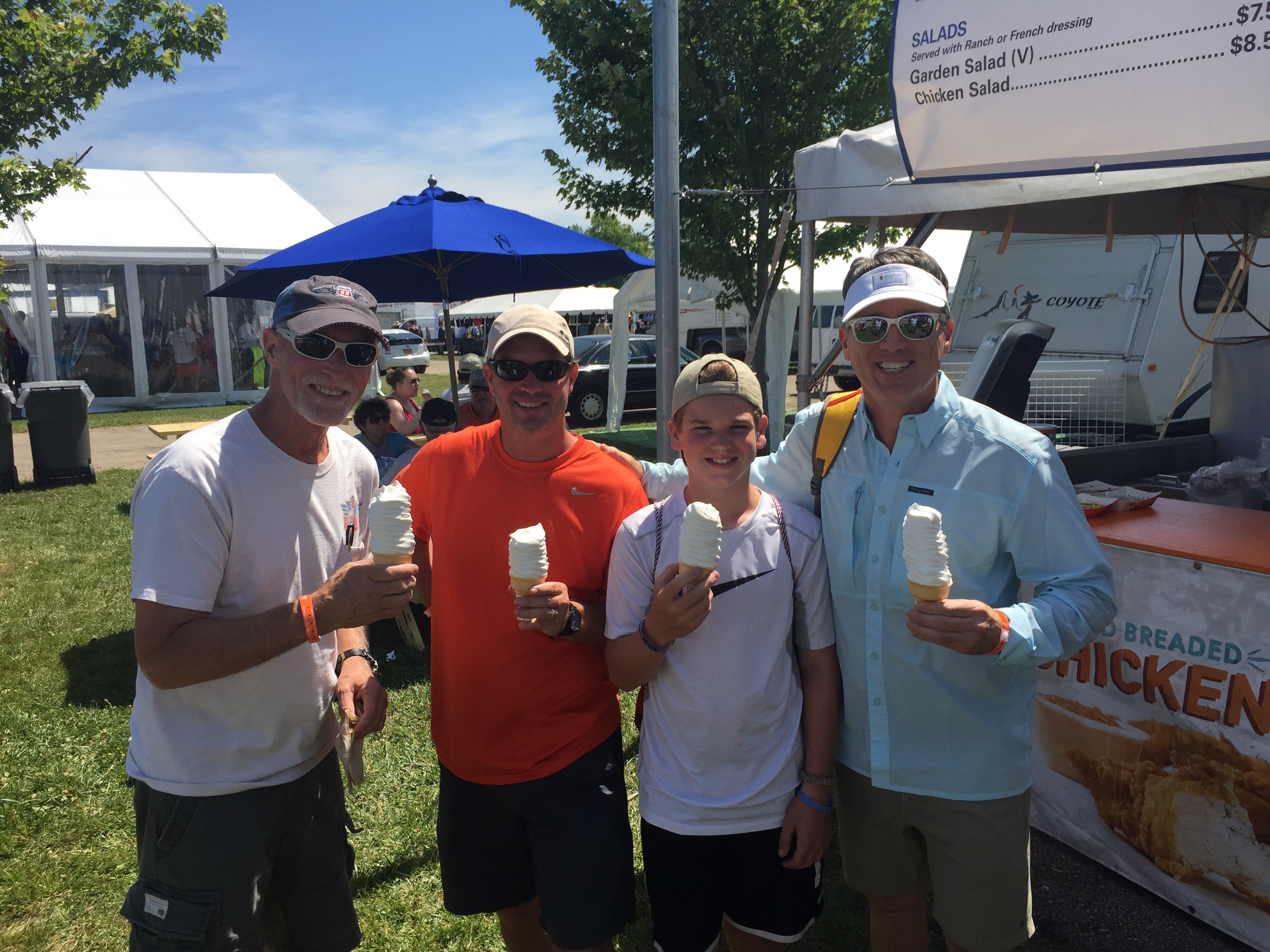 Group of four enjoying ice cream cones at an airshow