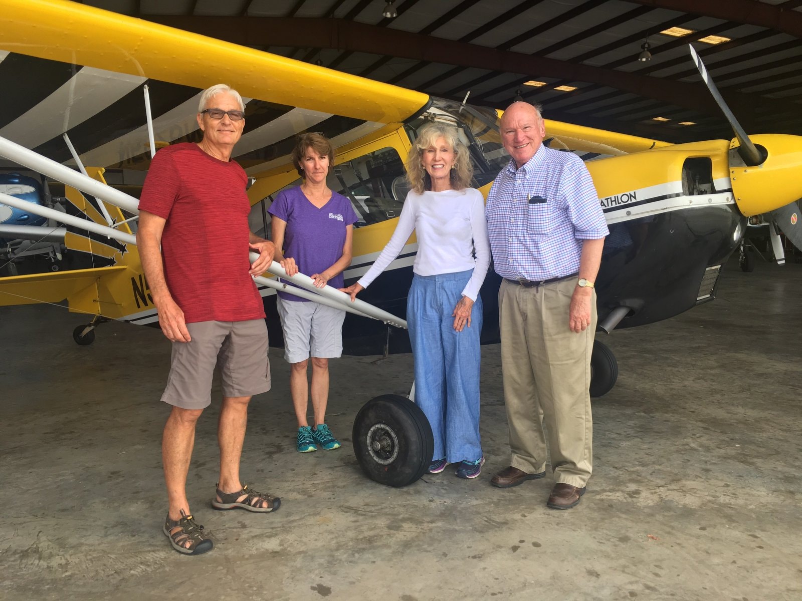 Group of four people in front of the yellow Decathlon in the hangar