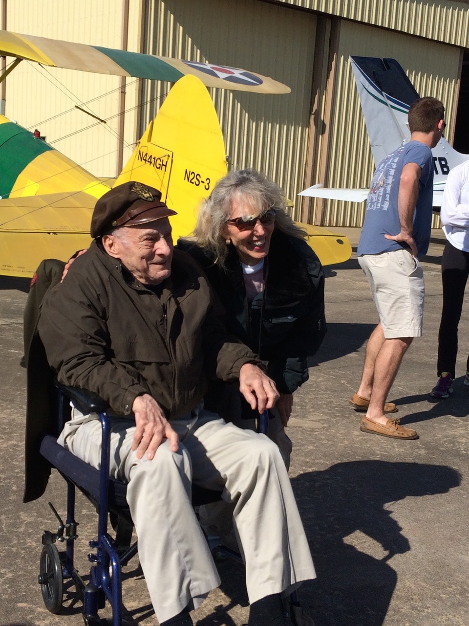 Two people at an aviation event with the Stearman N2S-3 in the background