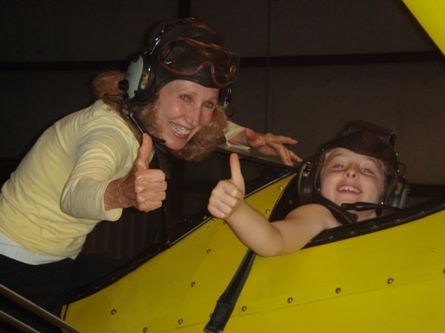 Instructor and young student giving thumbs up from the cockpit